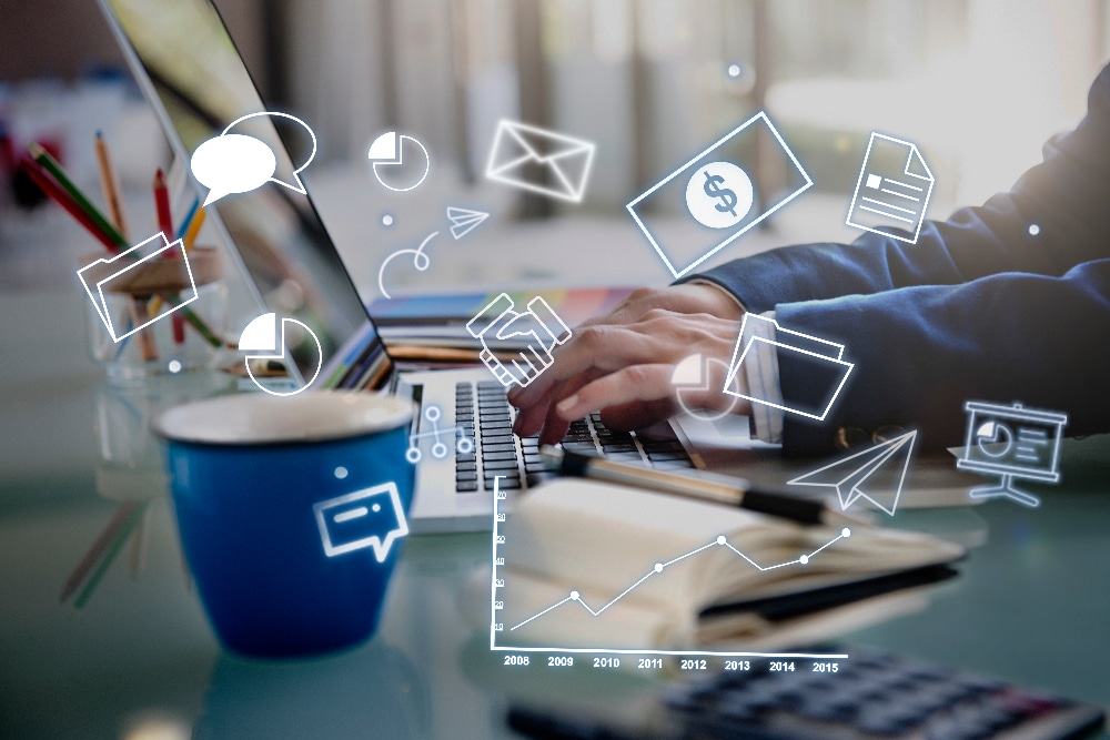 Person typing on laptop with marketing automation icons and graphs, illustrating digital marketing strategies for small businesses.